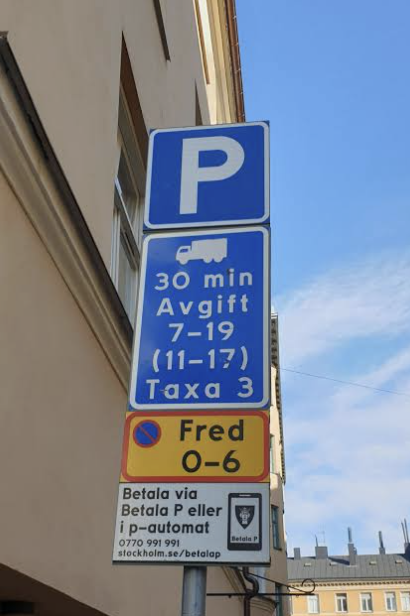 Fotografi av parkeringsskylt i Stockholm: P, lastbilssymbol, 30 min, Avgift 7–19 (11–17), Taxa 3, parkeringsförbud Fred 0–6 och betalinformation